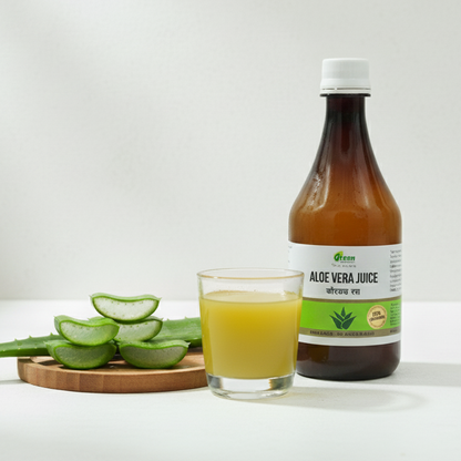 Bottle of aloe vera juice with a glass of juice and sliced aloe vera on a white background