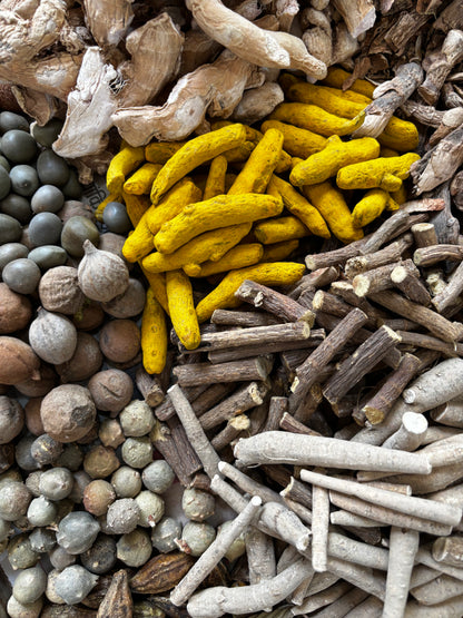 Colorful assortment of dried herbs and spices including yellow, brown, and gray.
